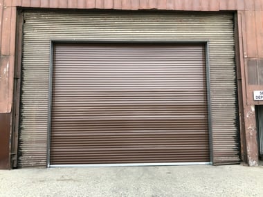 old commercial steel roll up door outside building view