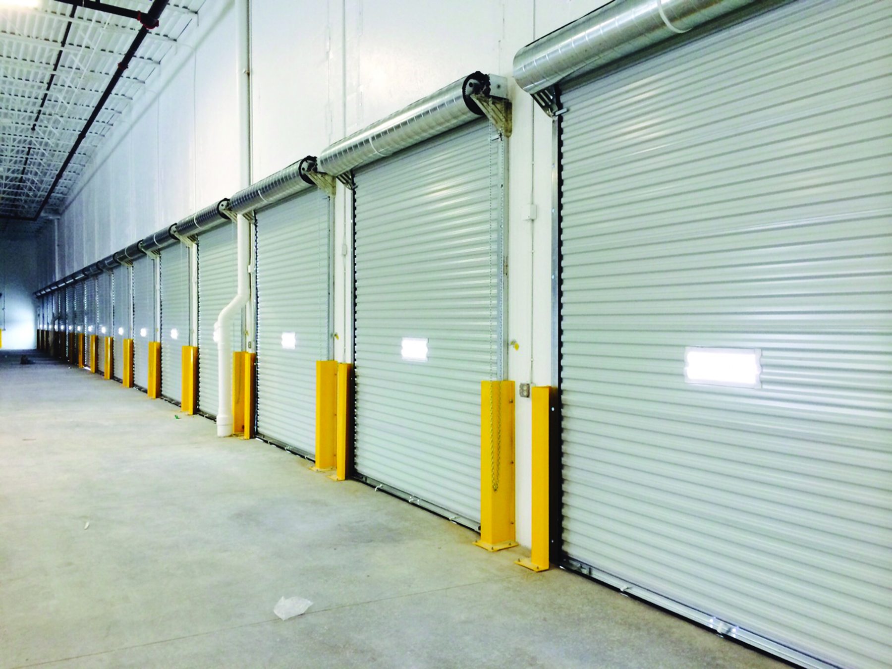 Row of white Janus 2500 Series doors inside a freight terminal