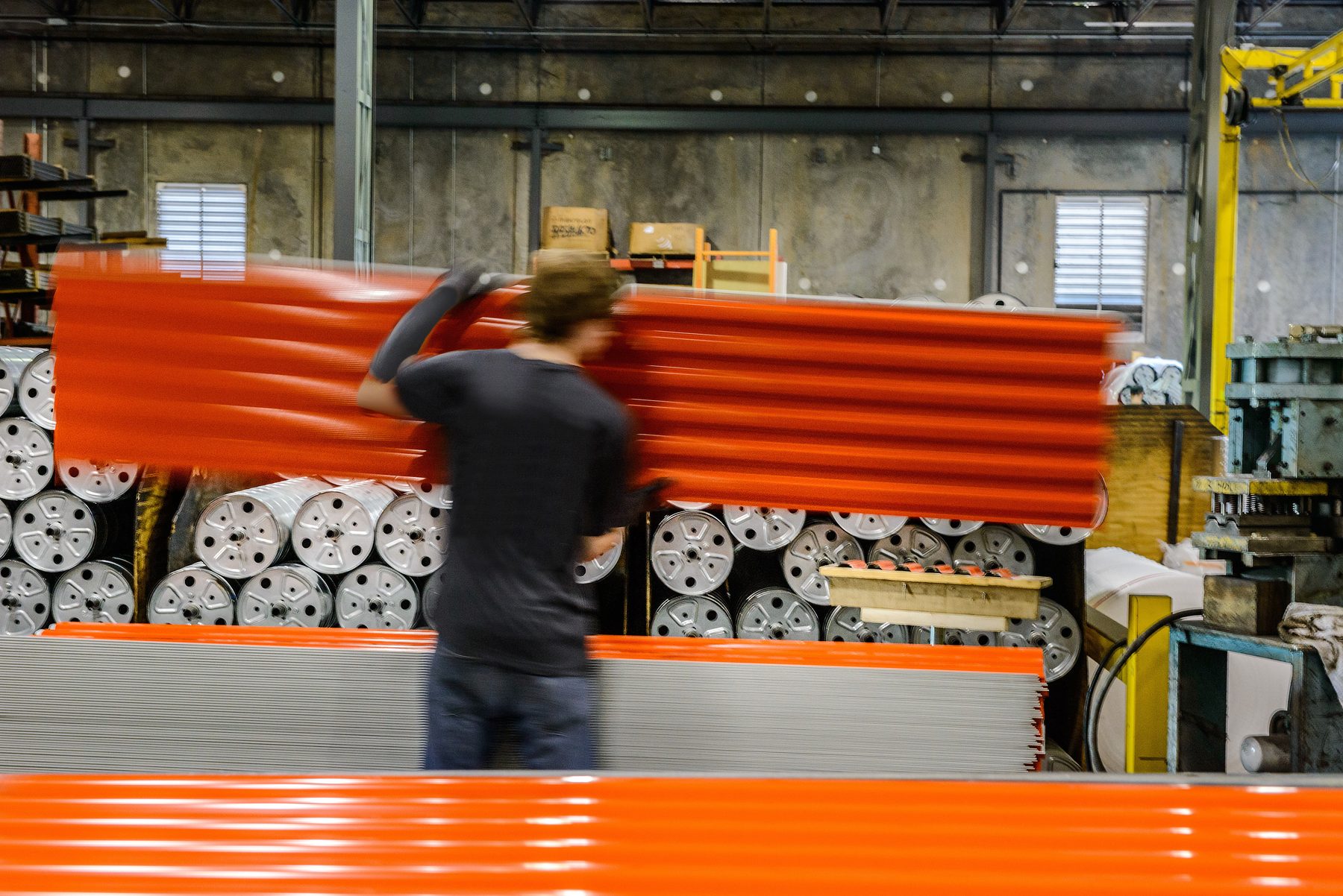 Janus team member carrying a painted door curtain in a Janus manufacturing plant