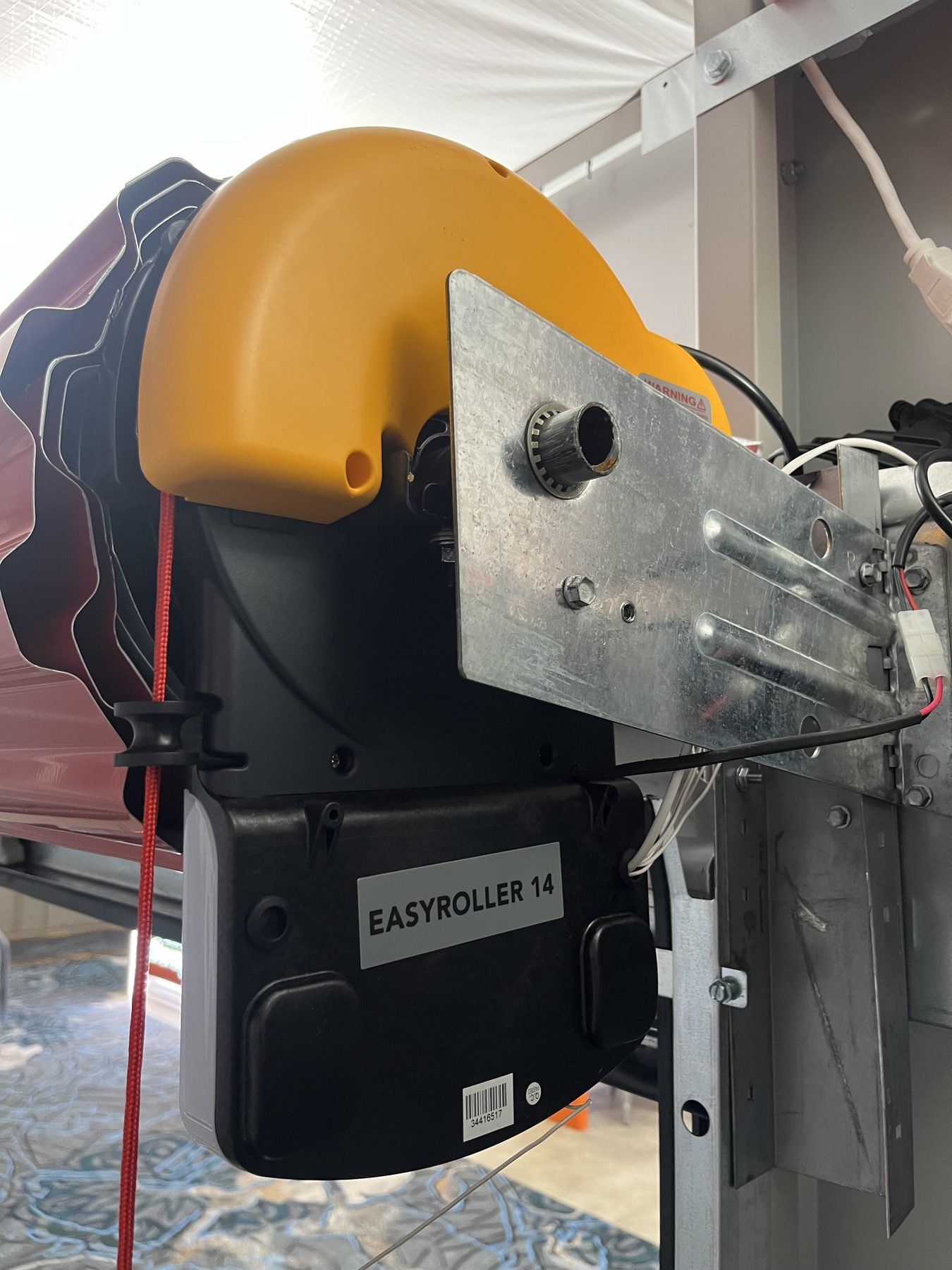 Close-up of an Easy Roller 14 operator mounted on a roll-up door bracket