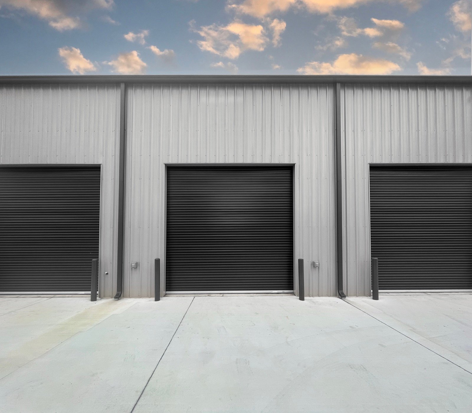 Black Janus Model 2000 roll-up door on a gray steel building