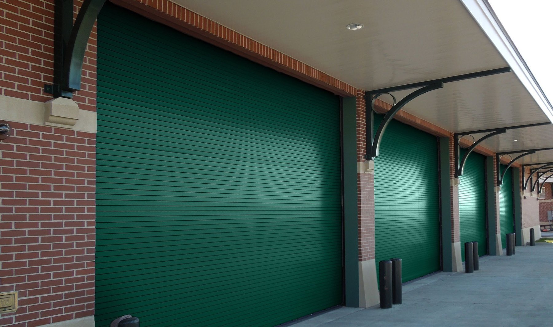 Janus 400HP Series green high performance rolling doors on a brick building