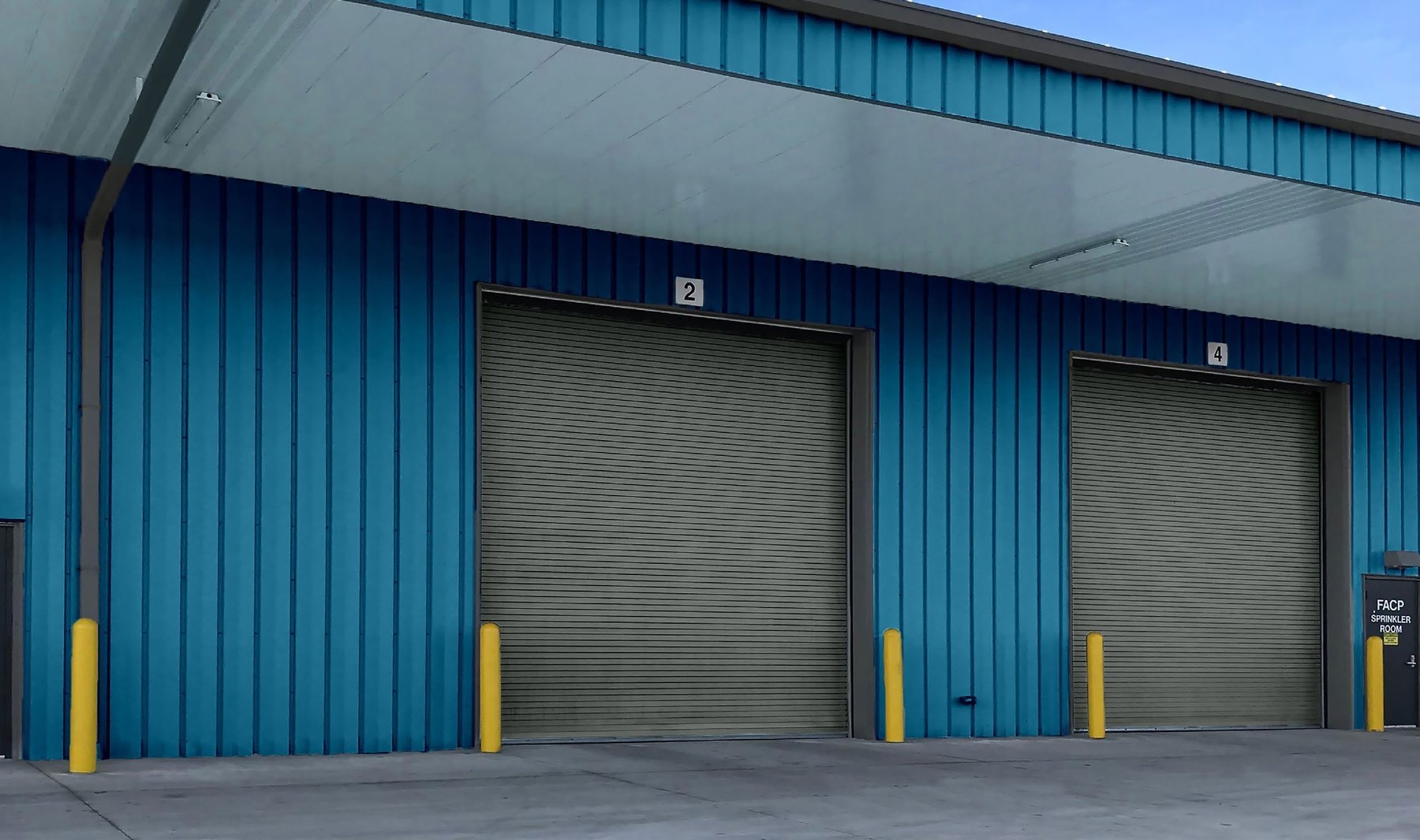 Janus 600 Series insulated rolling service doors on a blue steel building