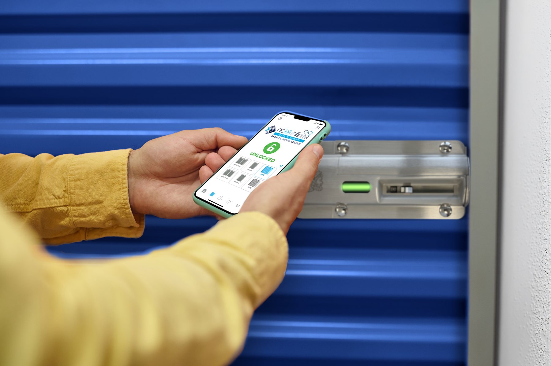 Close-up of a tenant unlocking a Nokē Infinitē smart lock on a blue Janus door with the Nokē app