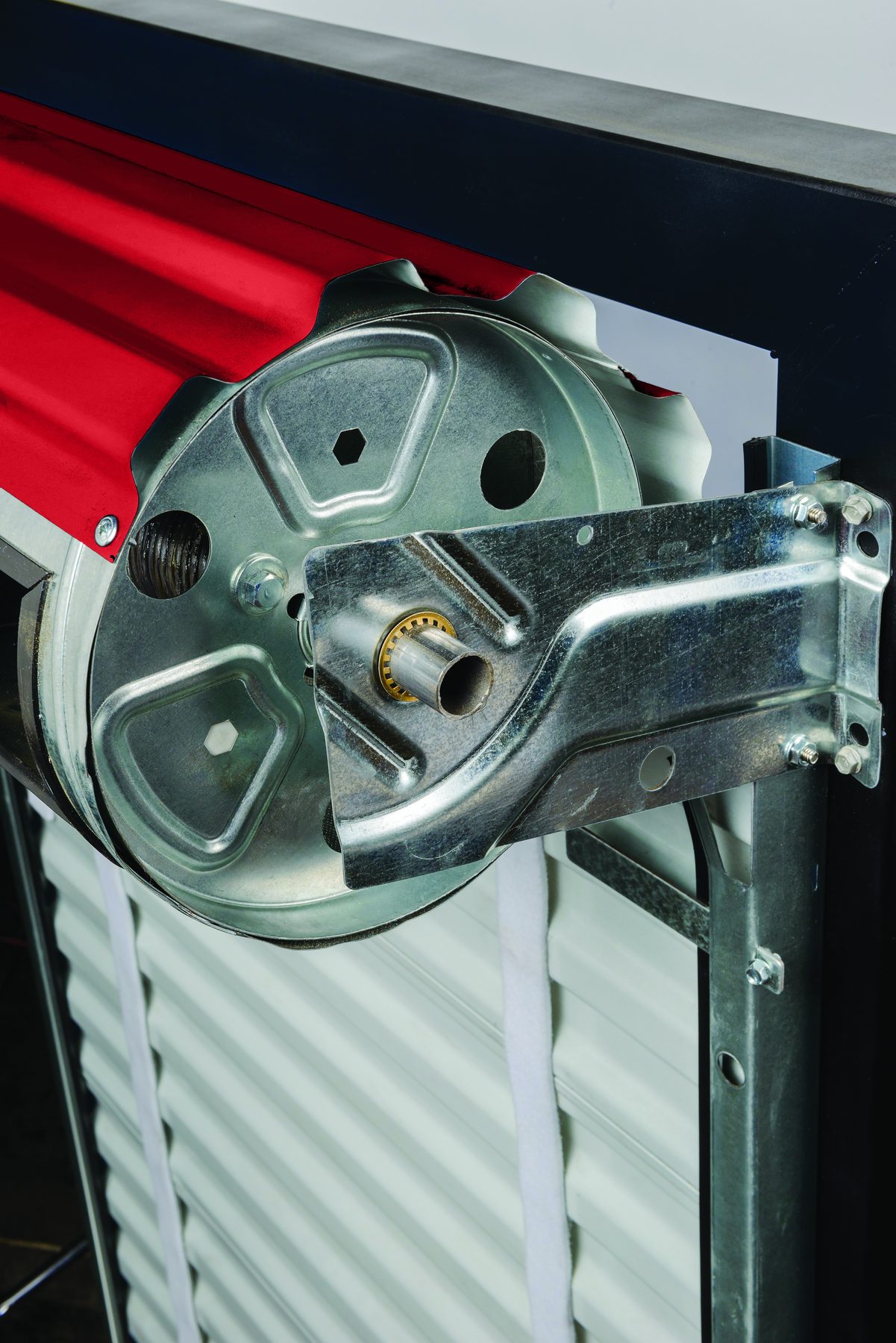 Close-up of the ratchet tensioning wheel and bracket on a red Janus 650 Series door