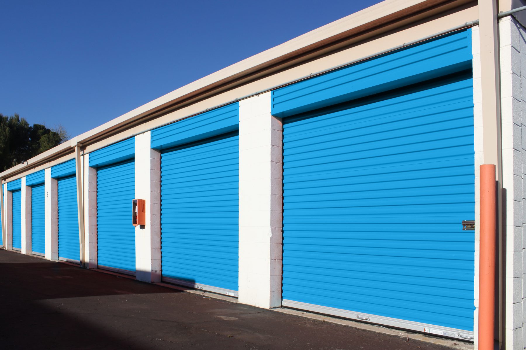 Row of Smart Blue Janus 650 Series roll-up doors on an outdoor drive aisle