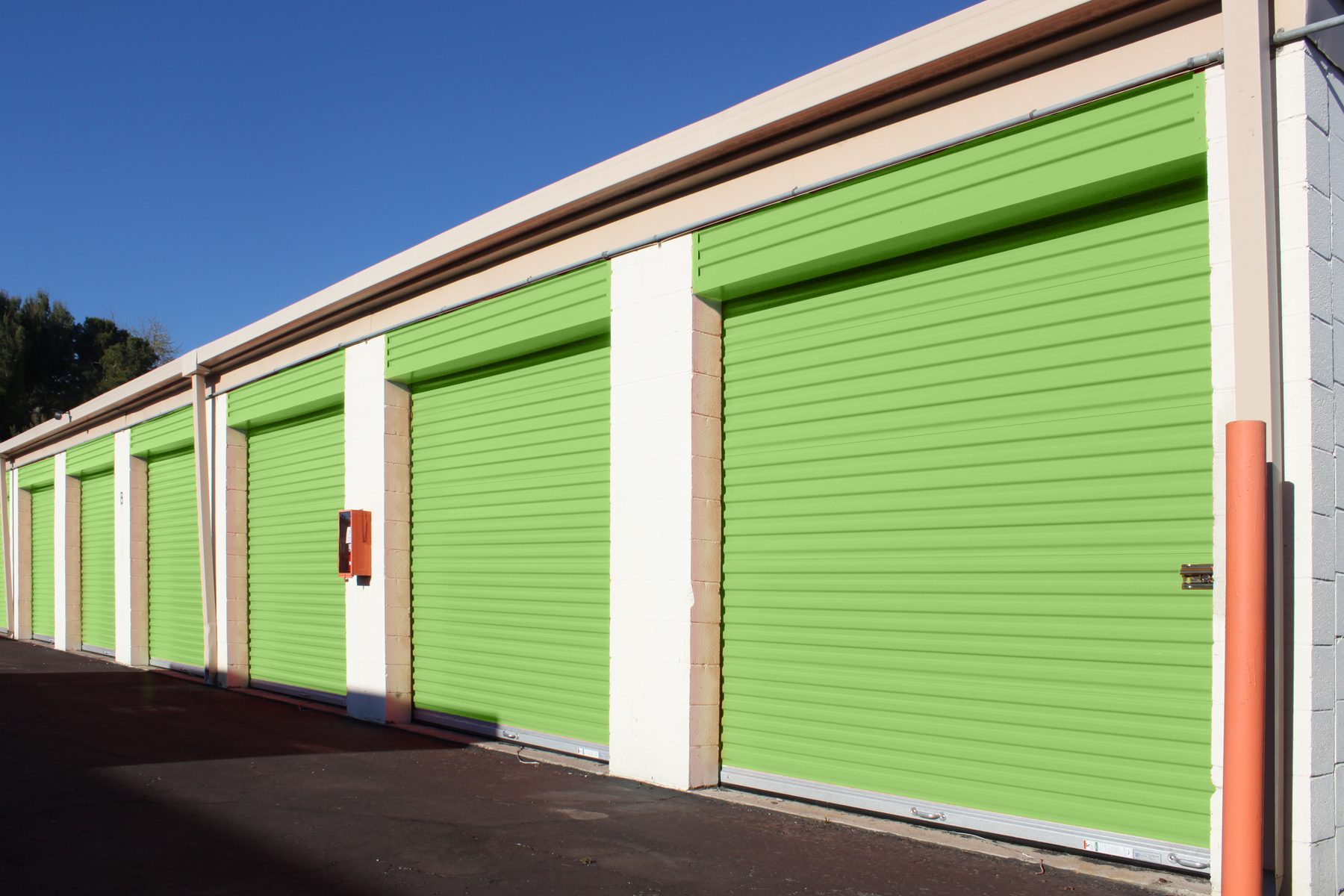 Drive aisle of green Janus 650 Series roll-up doors at a self-storage facility