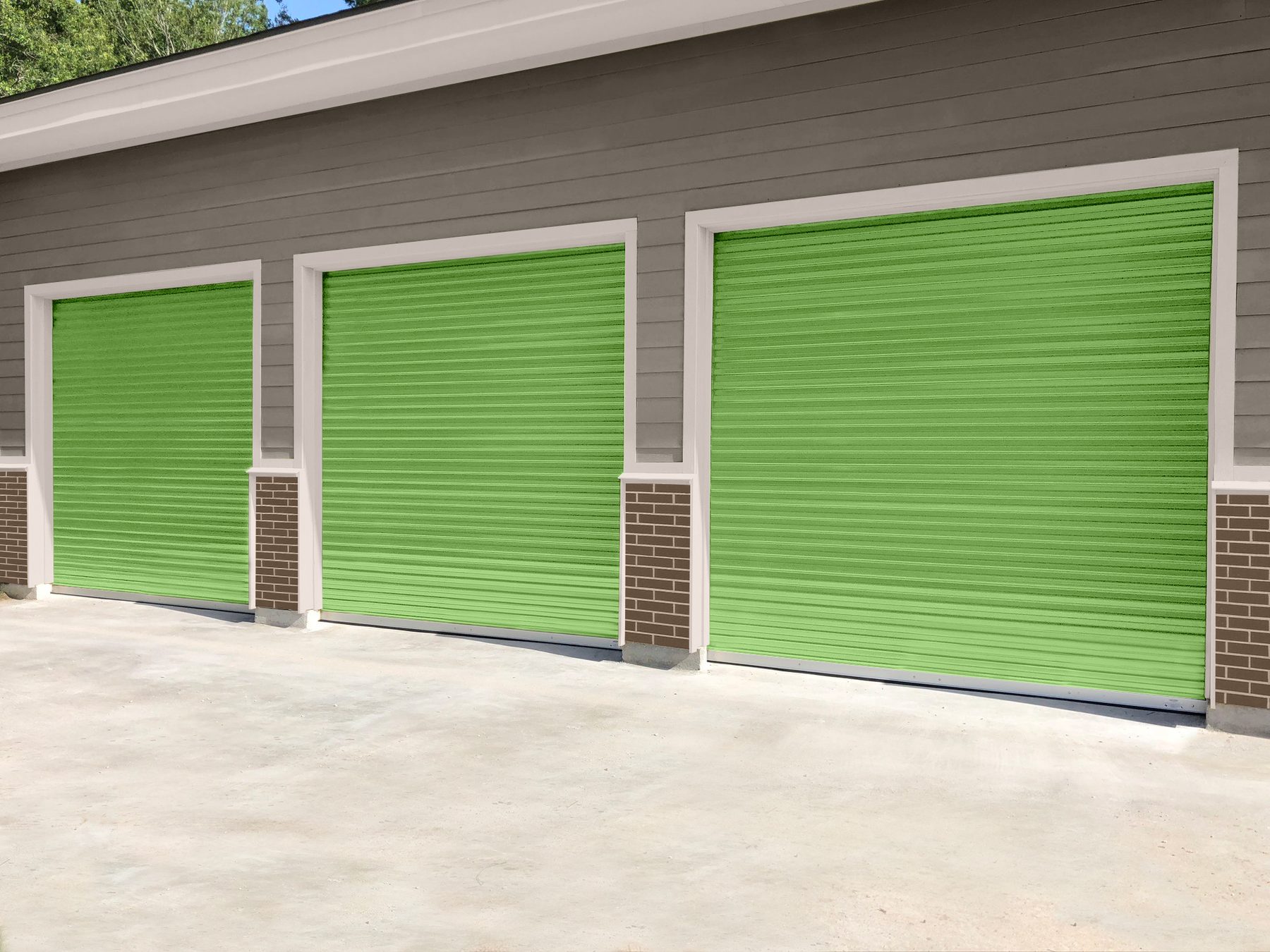 Three wide Wasabi green Janus 750 Series roll-up doors on an exterior building