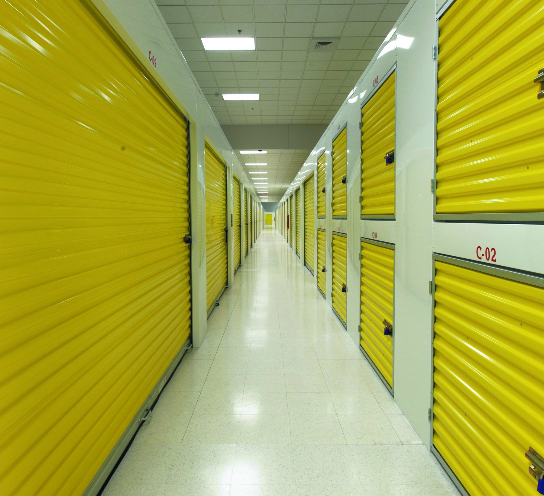 Interior hallway with yellow Janus roll-up doors and stacked lockers