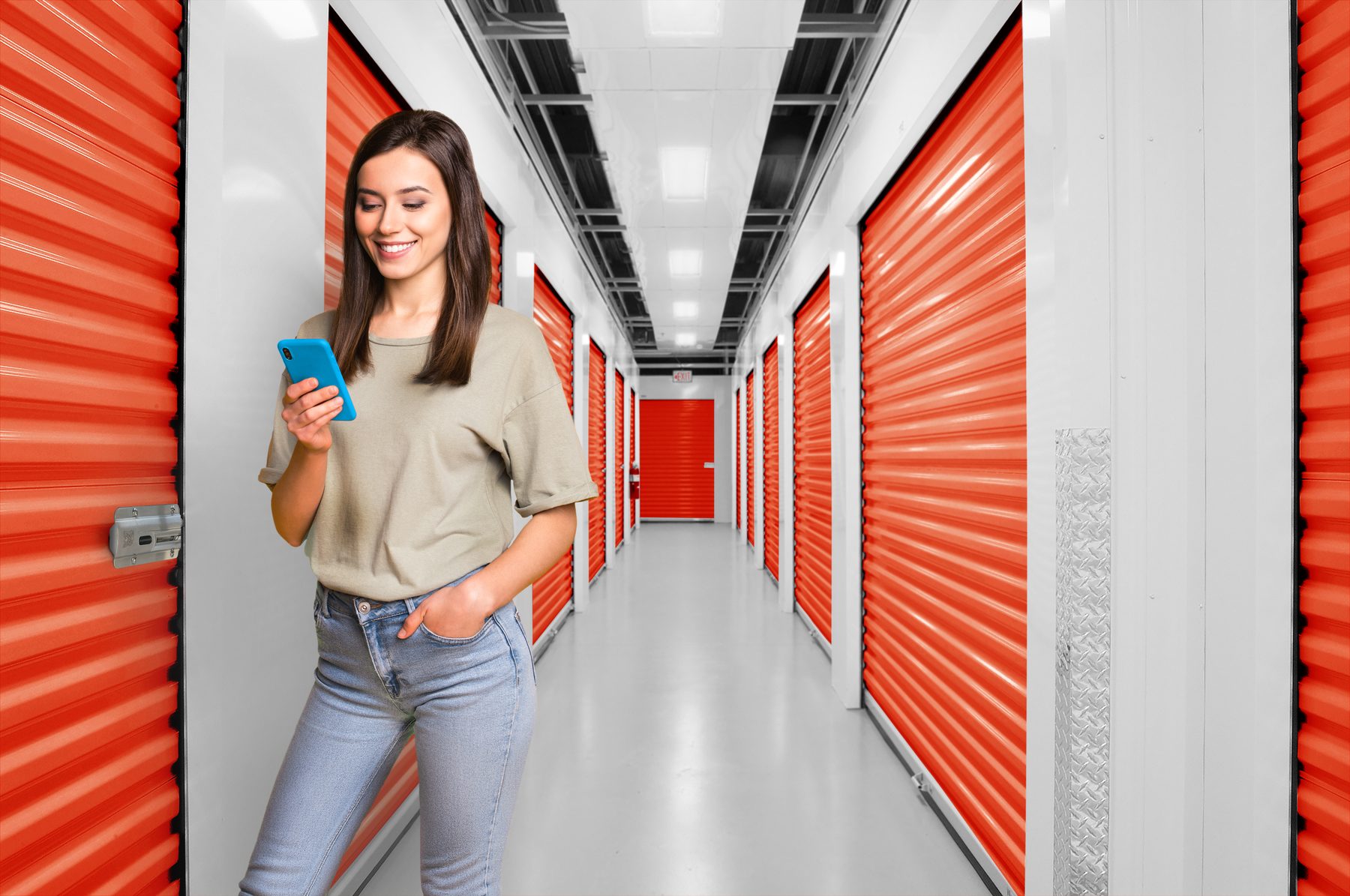 Tenant using the Nokē app beside an orange Janus roll-up door with a Nokē Infinitē smart lock