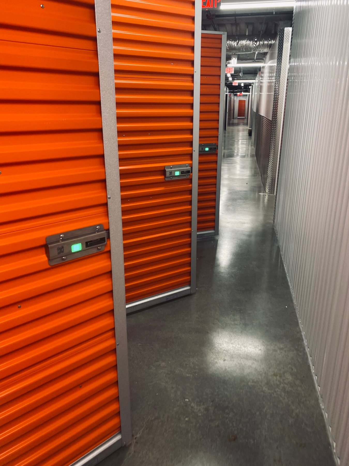Interior hallway of orange Janus swing doors, each with a Nokē Infinitē smart lock showing a green LED