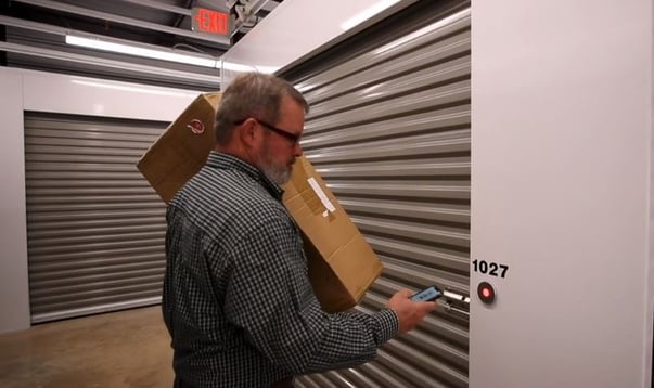 Man using smartphone to open the bluetooth lock on storage unit