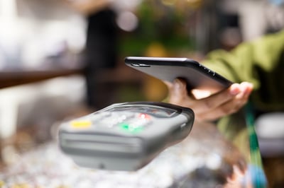 Woman paying with smartphone by NFC