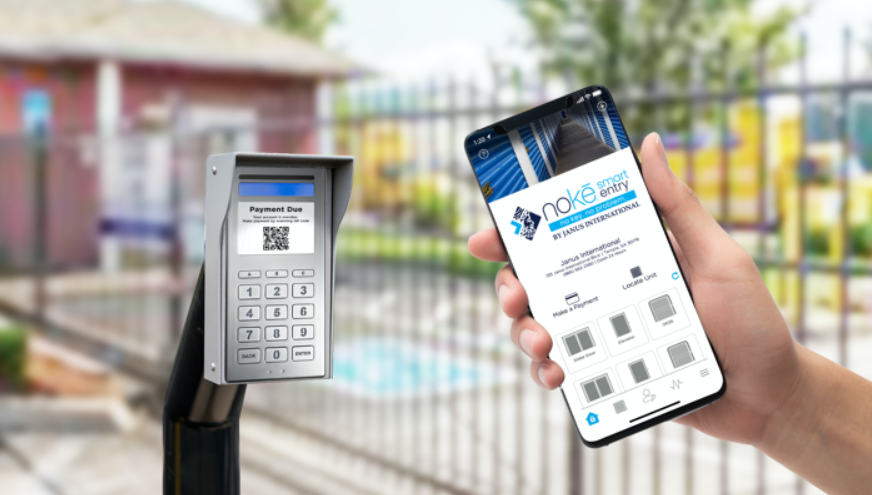 Nokē Screen smart keypad at a self-storage gate with a tenant holding the Nokē app on a smartphone
