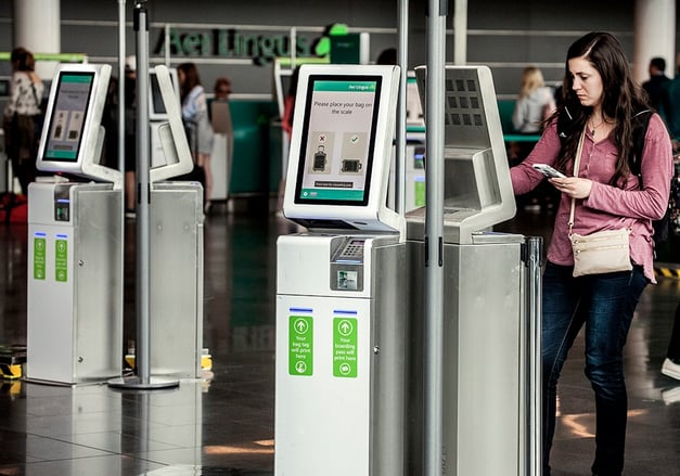 woman standing at a digital kiosk with other kiosks surrounding