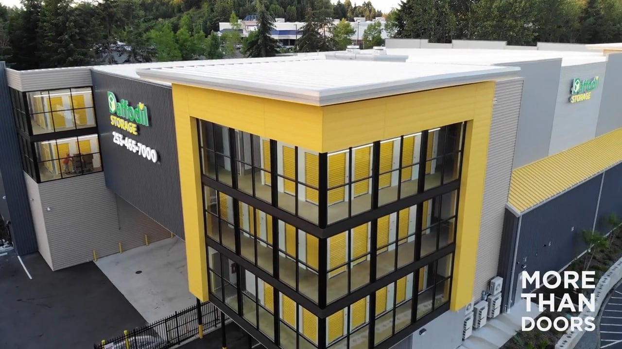Multi-story self-storage facility with yellow accents built with Janus