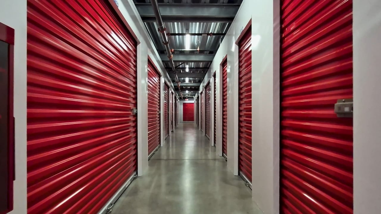 Red Janus roll-up doors in a Trojan Storage hallway